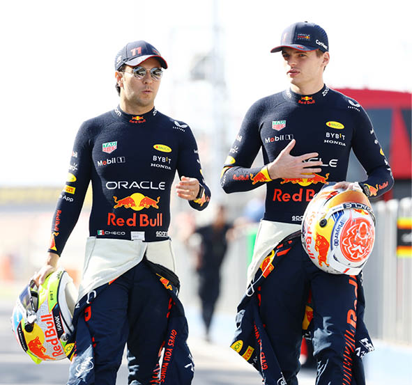 BAHRAIN, BAHRAIN - FEBRUARY 23: Sergio Perez of Mexico and Oracle Red Bull Racing and Max Verstappen of the Netherlands and Oracle Red Bull Racing talk during day one of F1 Testing at Bahrain International Circuit on February 23, 2023 in Bahrain, Bahrain. (Photo by Mark Thompson/Getty Images)